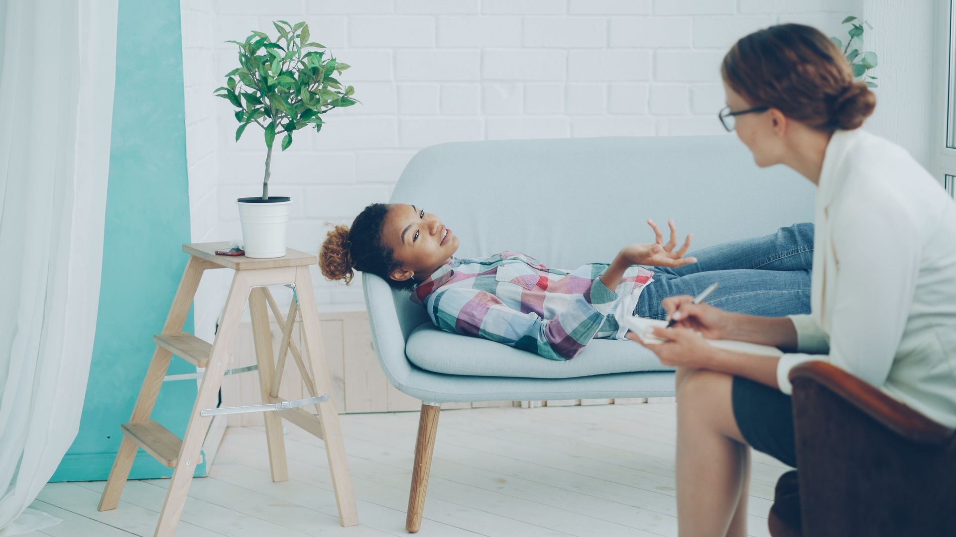 A client talking openly with her therapist in a bright, welcoming office