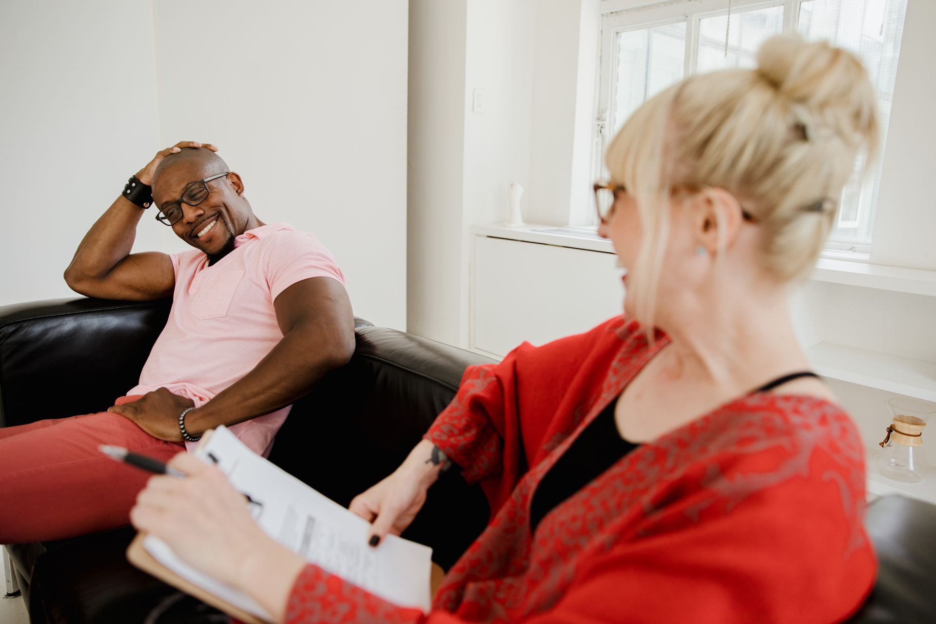A counselor and client sharing a relaxed, warm moment during a session