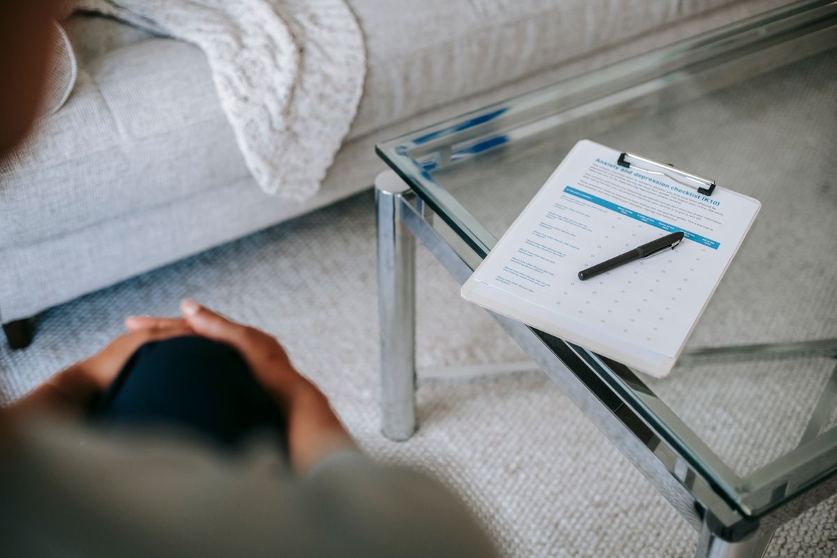 An anxiety and depression assessment checklist on a table beside a client